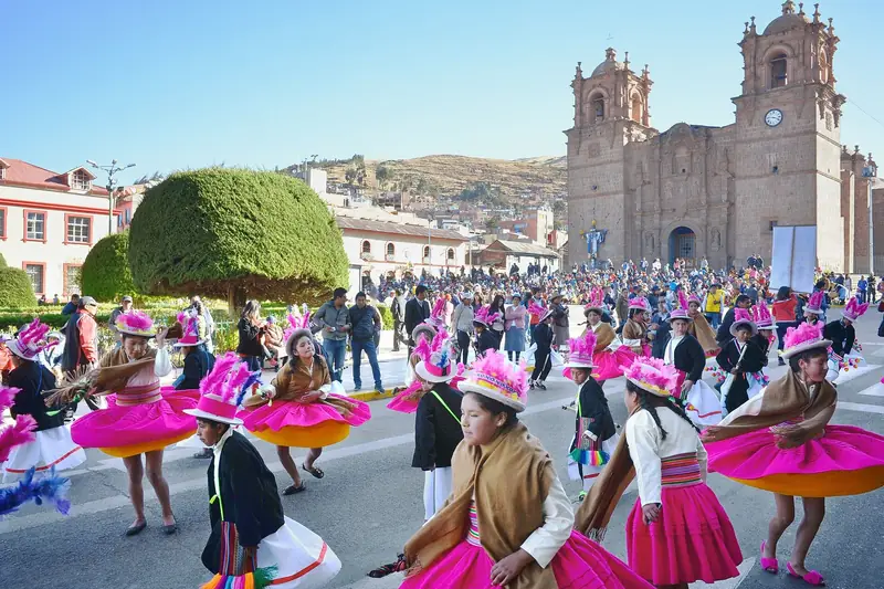 Bailarinas con trajes coloridos en una fiesta folclórica frente a la Catedral de Puno